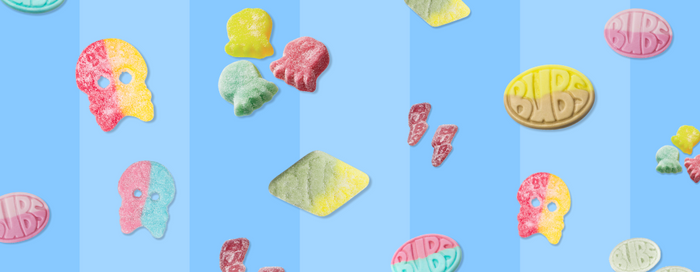 A vibrant blue background filled with Swedish BUBS candy, including sour bolts, giant skulls, and other sweets.